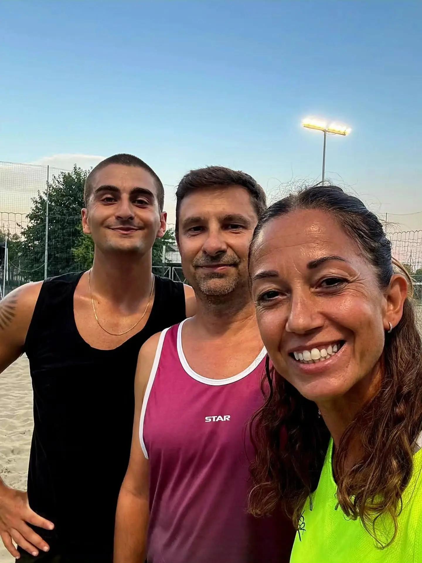 Tre partecipanti sorridono in un selfie su un campo di beach volley. Foto degli Open Days BVME 2026; le prossime date sono da verificare con lo staff.